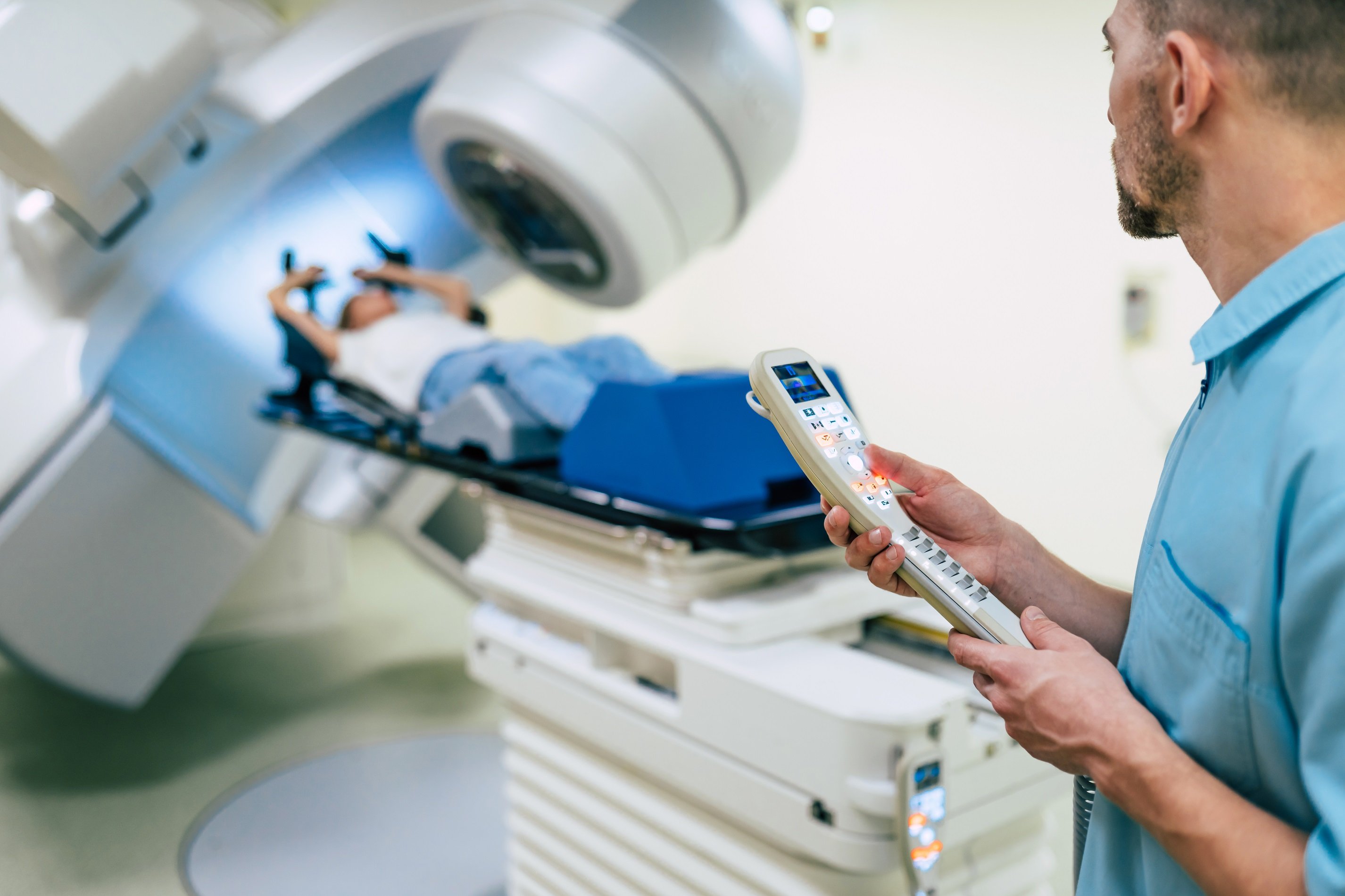 A doctor works while woman is undergoing radiation therapy for cancer.