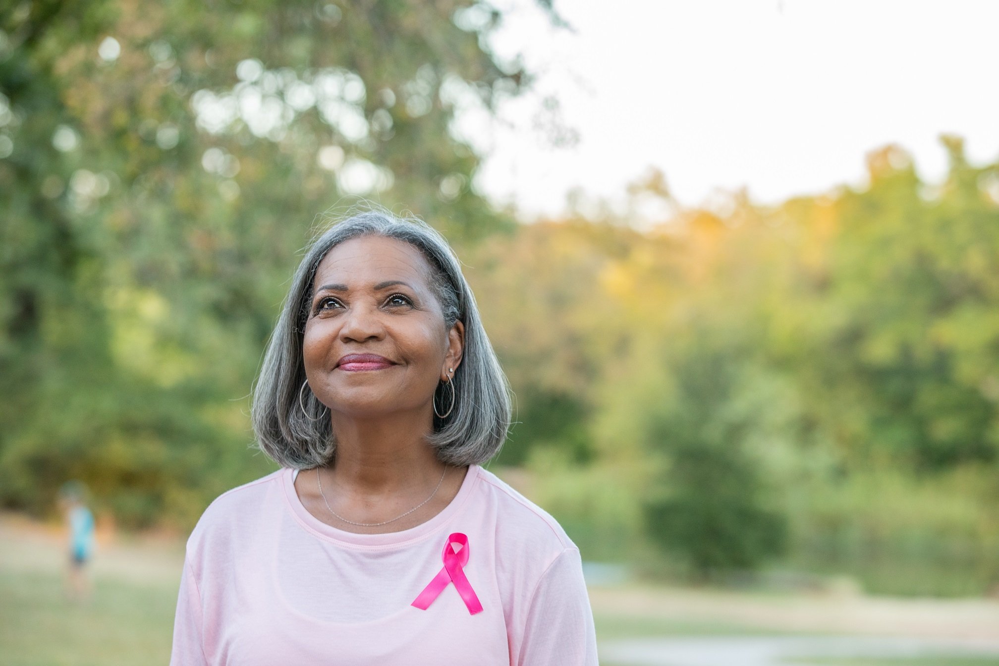 Senior woman smiles while walking for breast cancer awareness