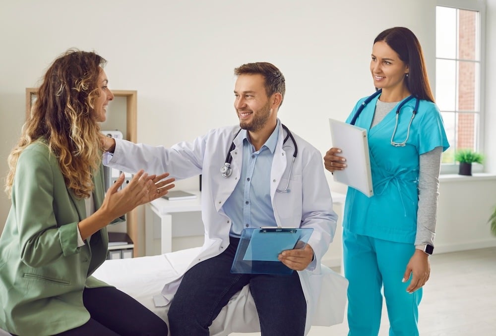 two doctors speak with female patient