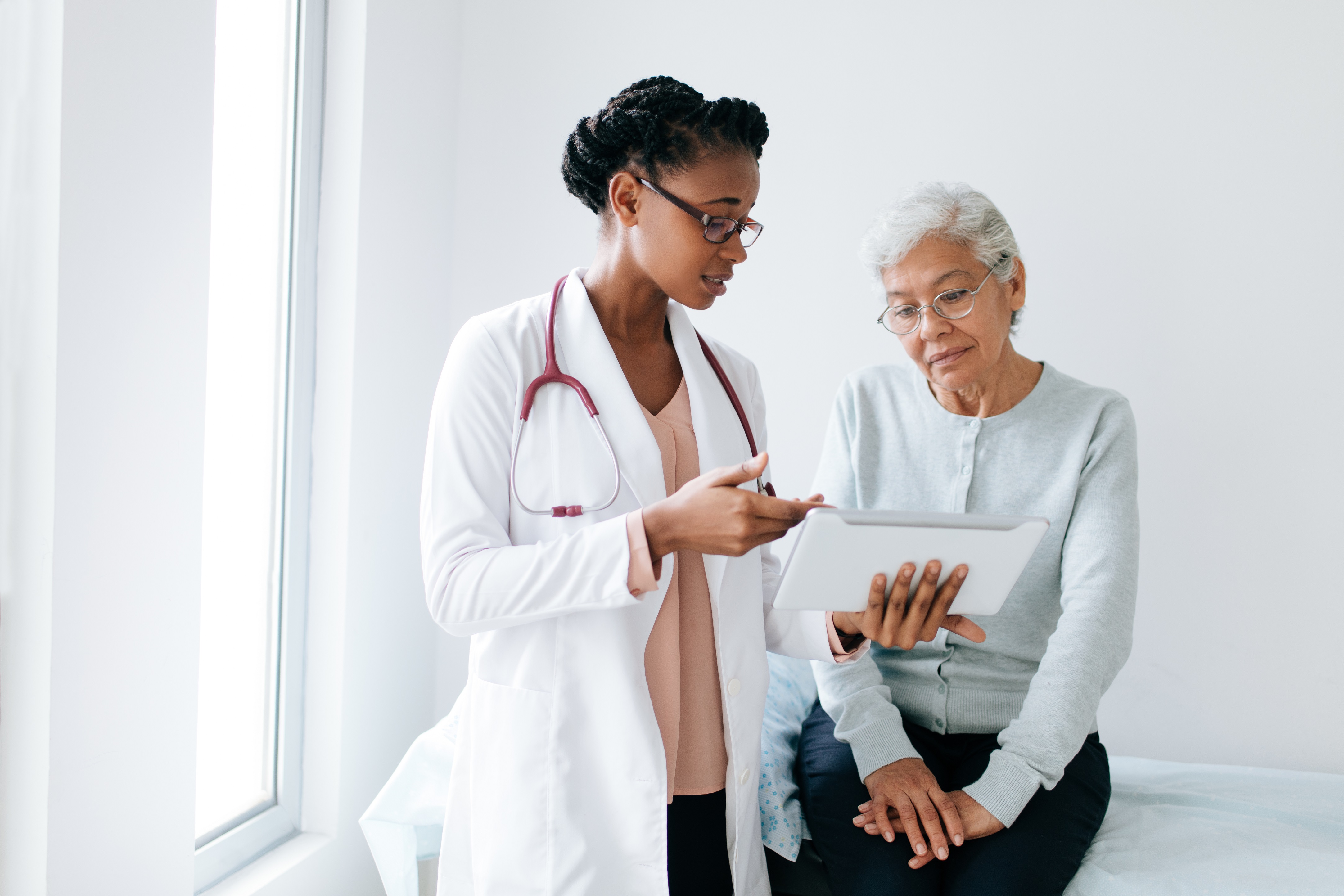 Una médica comenta los resultados de las pruebas con una paciente de edad avanzada