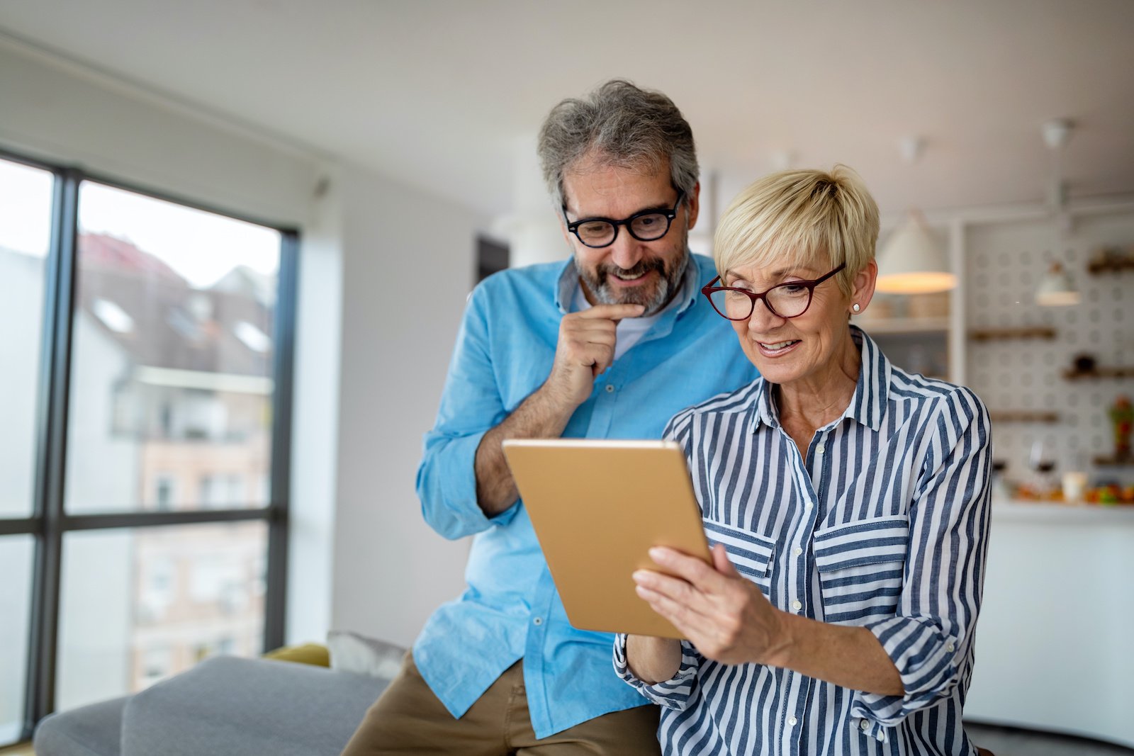 man and woman looking at ipad