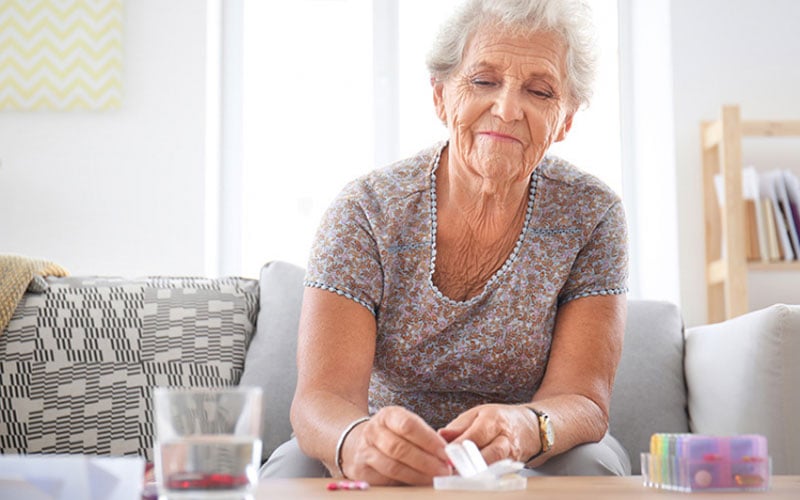 older woman taking her medication